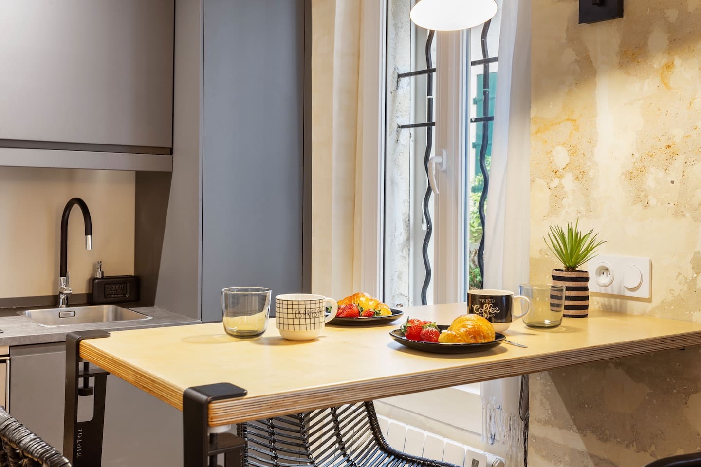 Cozy dining corner with natural light and French pastries in a luxury Paris rental