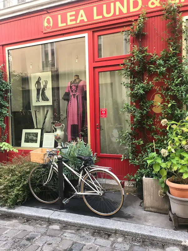 Local boutique with red façade and bicycle in Paris 11 near Cité Dupont