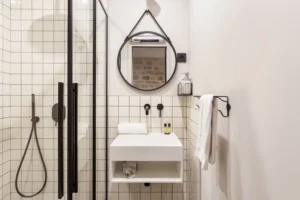 Modern bathroom with walk-in shower and black fixtures in Paris 11