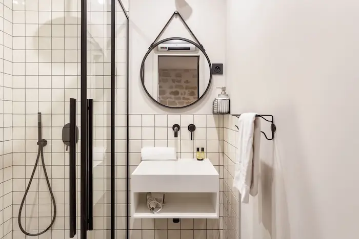 Modern bathroom with walk-in shower and black fixtures in Paris 11