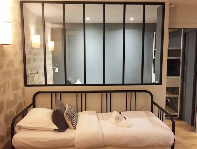 Daybed with cushions and stone wall detail in a Paris apartment